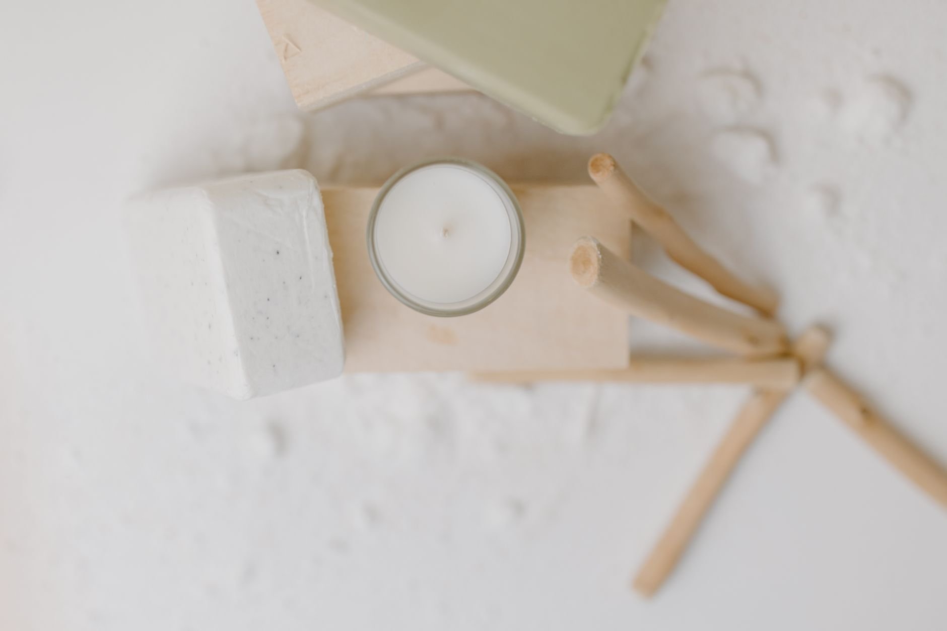A minimalist arrangement of soap, candle, and wooden elements for a calming, self-care atmosphere.
